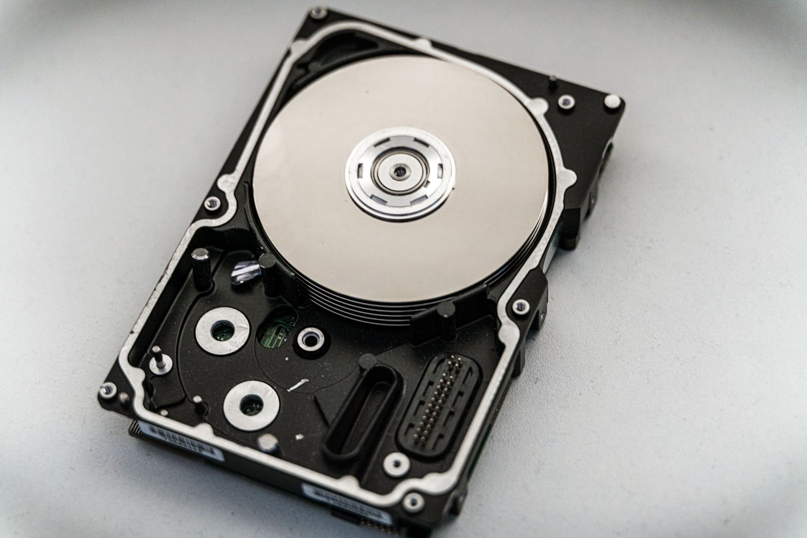 A hard drive opened to show the platter and read head.