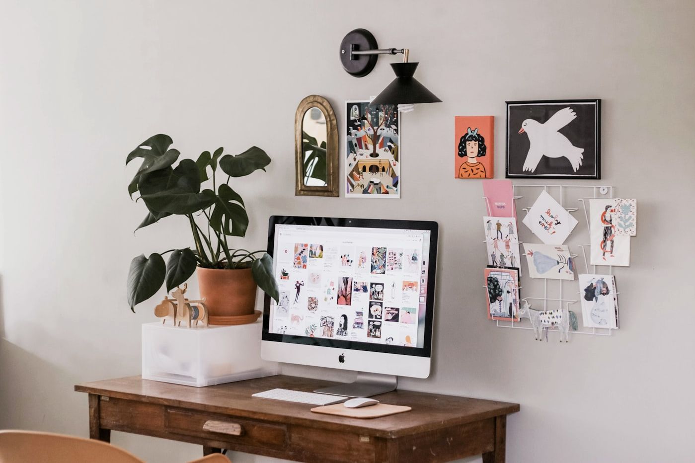 An iMac on a wooden desk in a home study.